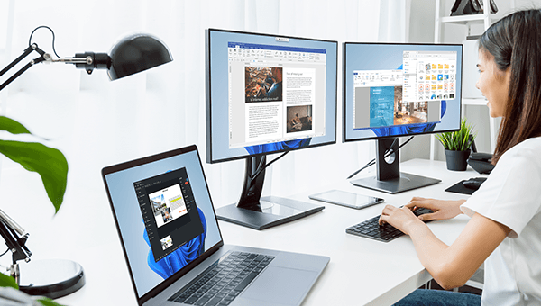 Woman working in front of three display.